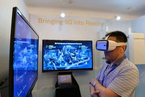嘉賓在峰會現(xiàn)場利用VR設(shè)備觀看5G測試外場。